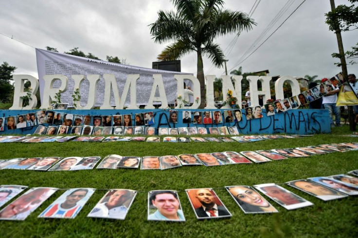 Page-sized photographs of the victims in clear plastic sleeves were placed on the ground and strung up on cables at an outdoor memorial at the town entrance