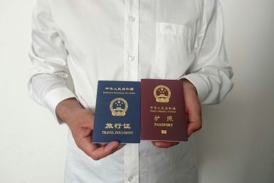 An unidentified Chinese Uighur man in the city of Medina holds his expired Chinese passport (red) and a one-way travel document (blue) issued in its place by the Chinese mission in Saudi Arabia