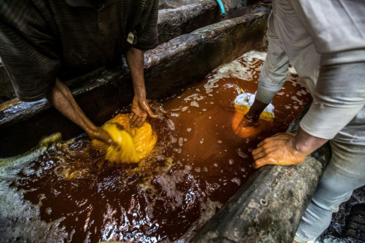 Workers dip the fabric in hot colour baths -- no gloves or masks protecting them from the dyes and chemical fumes.