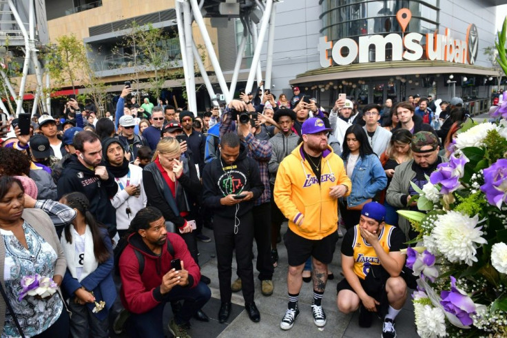 People gather around a makeshift memorial for former NBA and Los Angeles Lakers player Kobe Bryant at LA Plaza