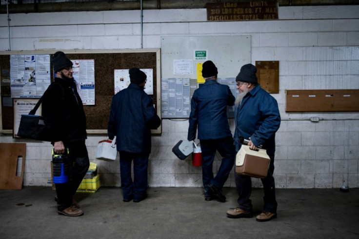 Workers punch out with their time cards after completing their workday at the Riverside RV plant