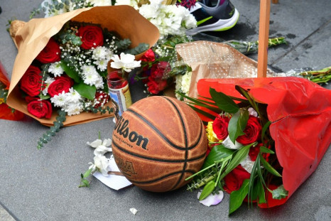 Fans gather around a makeshift memorial for former NBA and Los Angeles Lakers player Kobe Bryant after learning of his death at LA Live plaza near Staples Center in Los Angeles on January 26, 2020.