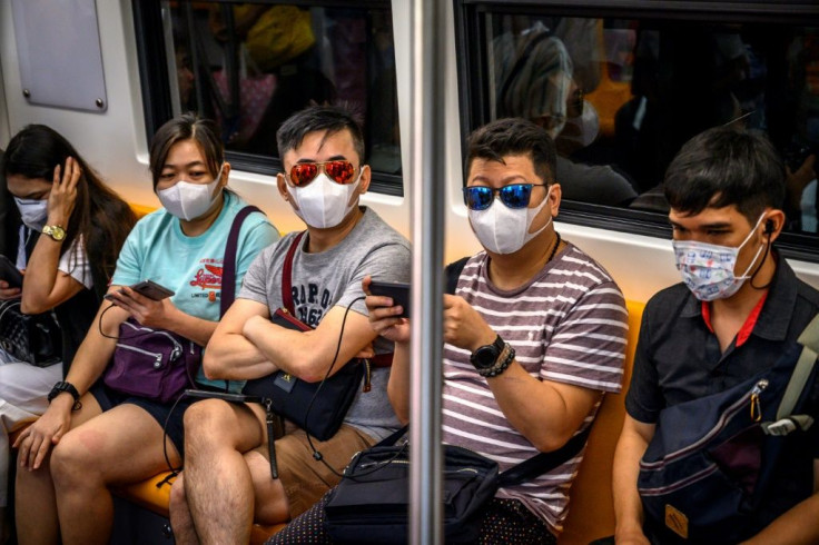 People with face masks ride a BTS Sky train in Bangkok, Thailand, which has detected eight virus cases so far, three receiving treatment in hospital and five discharged