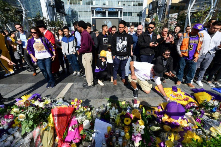 Fans place flowers, candles and other mementos to honor Kobe Bryant at LA LIVE plaza in Los Angeles
