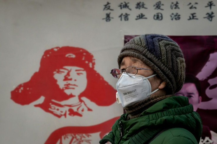 A woman in Beijing wears a protective mask to help stop the spread of the coranavirus, which has killed more than 100 people