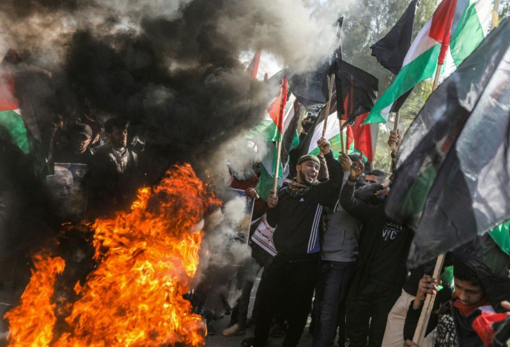 Palestinian demonstrators chant by flaming tyres during a protest against US President Donald Trump's expected peace plan proposal in Gaza City