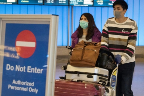 Passengers wear masks to protect against the spread of the Coronavirus as they arrive at the Los Angeles International Airport