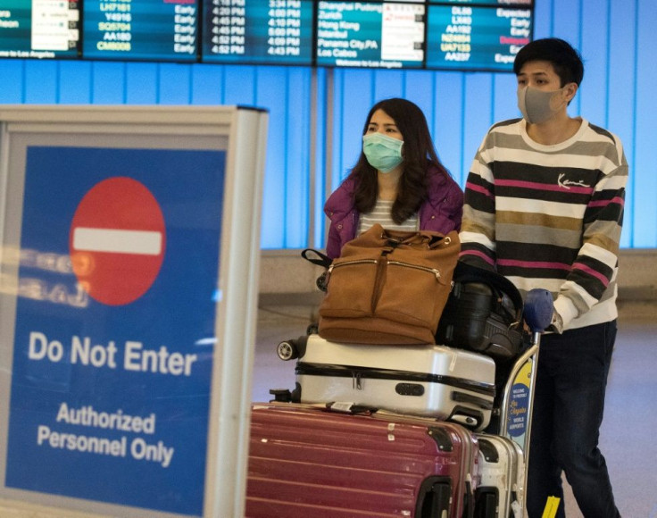 Passengers wear masks to protect against the spread of the Coronavirus as they arrive at the Los Angeles International Airport