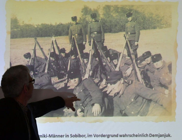A staff member of the Topography of Terror archive points at a historical photograph allegedly showing convicted Nazi guard John Demjanjuk at the Sobibor camp