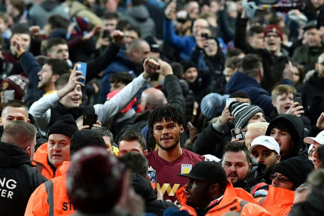 Aston Villa's defender Tyrone Mings is mobbed as fans poured onto the pitch after their 2-1 win over Leicester