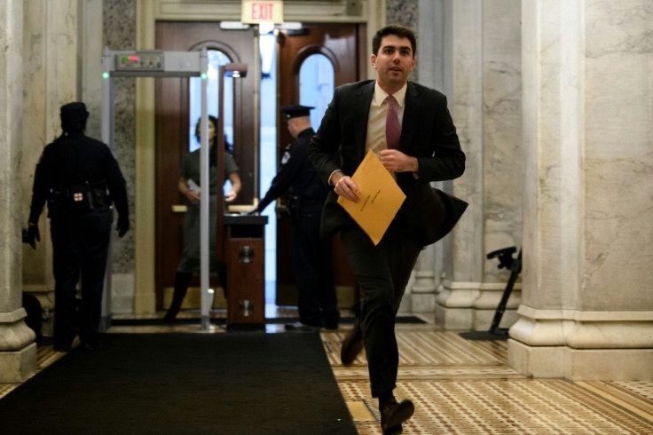 Tony Hanagan, a staff member of the Republican Cloakroom, runs with a document during the impeachment trial, which has been roiled by leaks from a forthcoming book by John Bolton