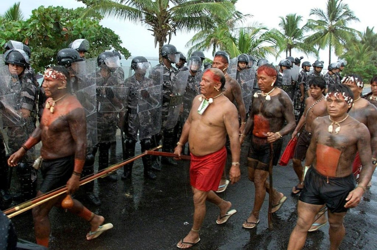 Members of the Yanomami tribe walk past military police in April 2000 in Coroa Vermelha, Brazil as they gather for protests to coincide with celebrations of the 500th anniversary of the arrival of Portuguese explorers