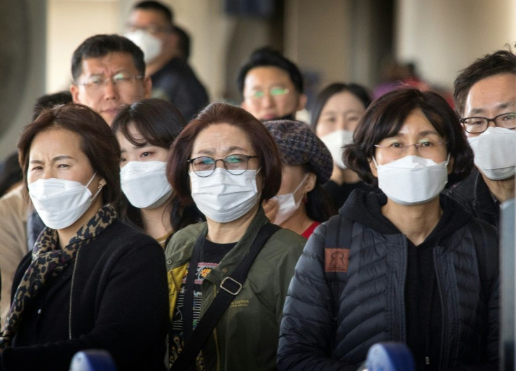 Passengers wearing face masks arrive on a flight from Asia at Los Angeles International Airport, California