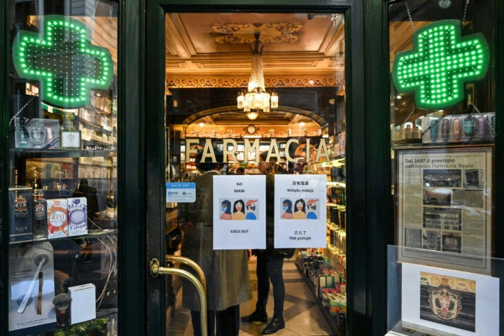 A sign in various languages, including Chinese, tells customers that masks have sold out at a pharmacy in Rome