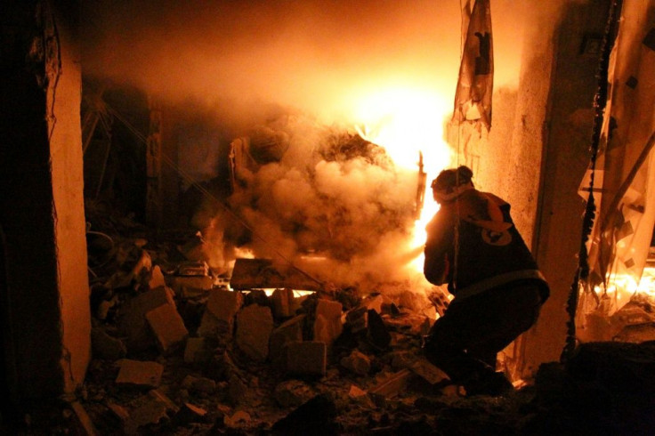 A volunteer firefighter battles a blaze after a night-time air strike on the Idlib province town of Ariha