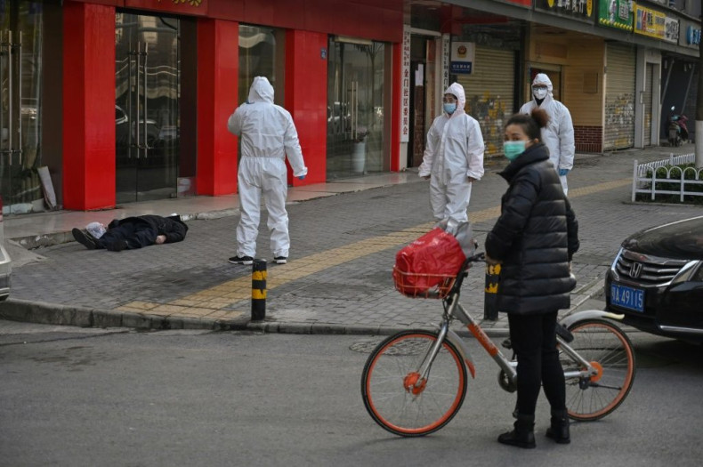 AFP reporters witness police and medics in protective suits dealing with a dead body in Wuhan