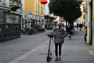 A woman wearing a mask walks in Via Paolo Sarpi, the commercial street in a Chinese district of Milan