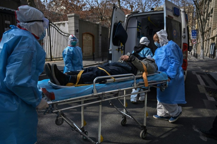 Medical staff in protective clothing carry a suspected virus patient from an apartment in the central Chinese city of Wuhan, the epicentre of the outbreak