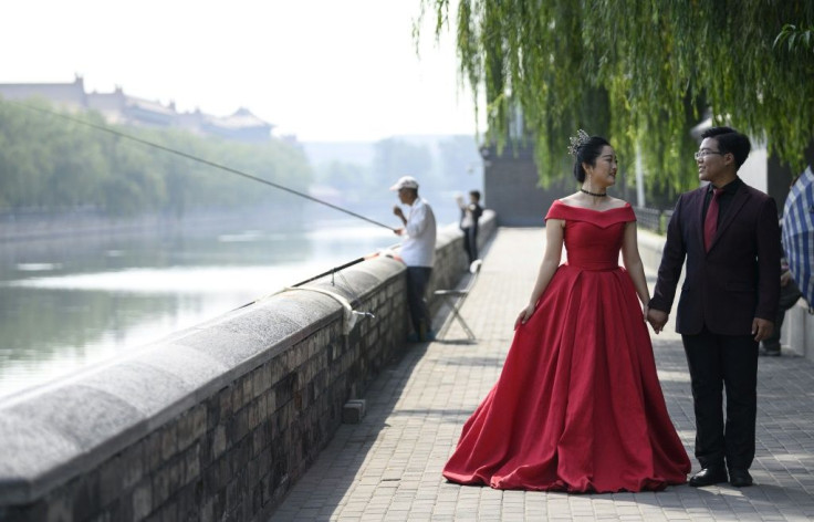 A couple pose for pre-wedding pictures at the north gate of the Palace Museum in Beijing