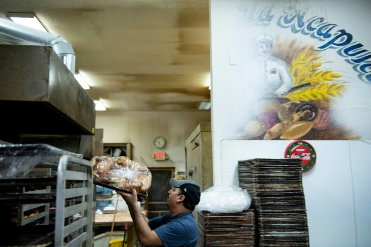Omar Cardoso places loaves of bread on a shelf after wrapping them at the Acapulco Mexican Bakery & Grocery in West Liberty, Iowa.