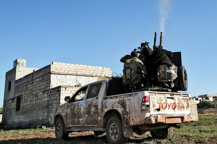 Turkish-backed Syrian fighters man an anti-aircraft gun in the town of Saraqeb in Idlib province