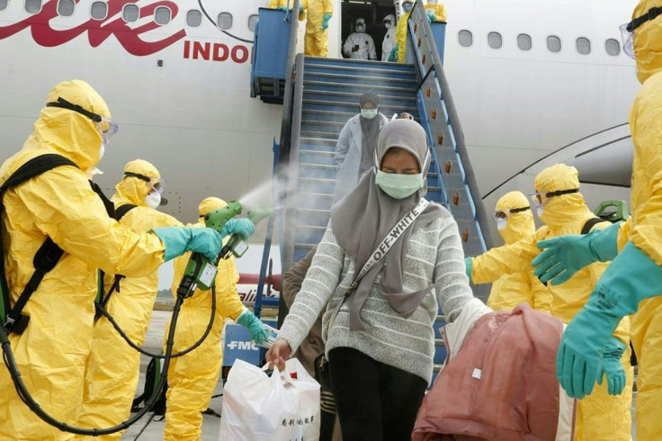 Health officials disinfect the evacuees from Wuhan, who will be quarantined on the island of Natuna for two weeks