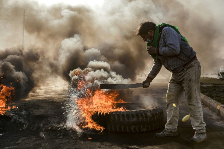 Anti-government protesters cut off a road with flaming tyres during a demonstration against Iraq's prime minister-designate Mohammad Allawi in the shrine city of Najaf, south of the capital