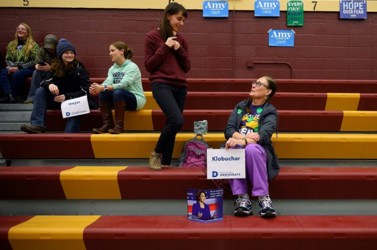 Madeline Kinkel (2nd R) tries to persuade her mother Karen Kinkel to leave Democratic candidate Amy Klobuchar and support Bernie Sanders instead, at a caucus at Abraham Lincoln High School in Des Moines, Iowa, on February 3, 2020