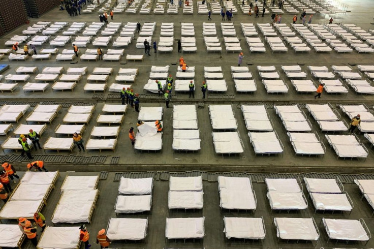 Workers set up beds at an exhibition centre converted into a hospital in Wuhan in China's central Hubei province