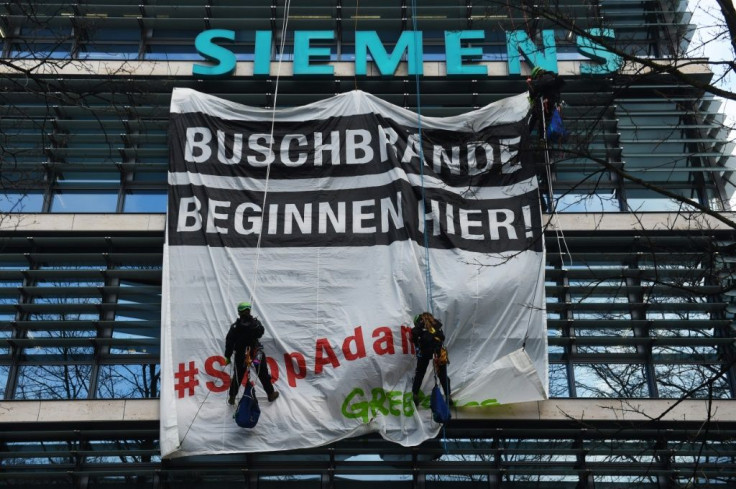 Greenpeace activists drape Tuesday a banner on top of German industrial giant Siemens headquarters ahead of a shareholders meeting set to be dominated by protests over a major Australian coal contract