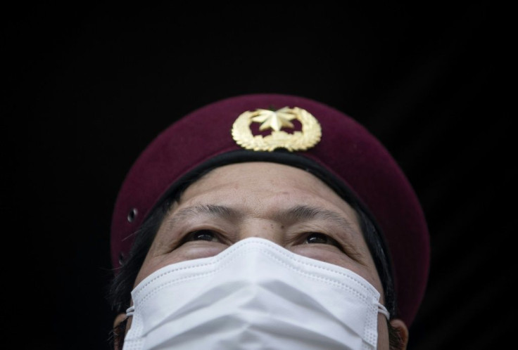 Security guards in Hangzhou take details from residents in order to enforce the limits on outbound trips