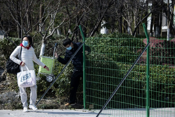 Green fences and "no entry" signs block streets near the headquarters of Alibaba, in a city hit by China's deadly viral epidemic