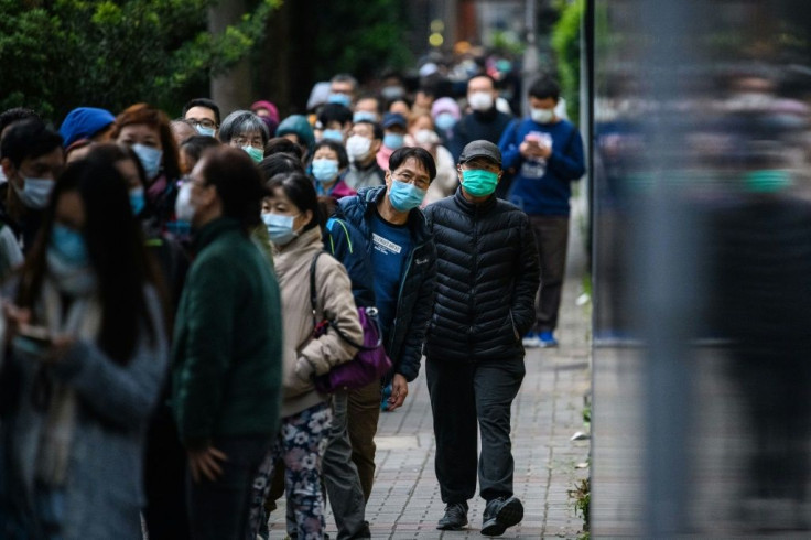 People queue for hours to purchase face masks from a makeshift stall in Hong Kong