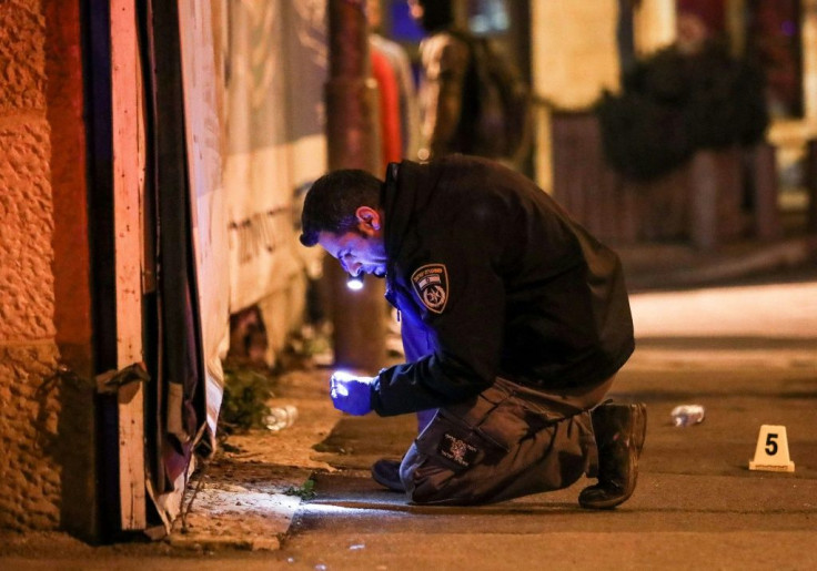 An Israeli policeman inspects the scene of a Jerusalem car-ramming that wounded 14 Israelis, most of them soldiers