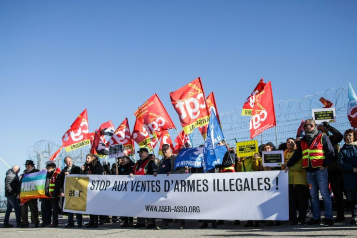 People hold a banner reading "Stop the sale of illegal weapons" during a demonstration at Cherbourg harbor