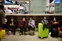 Passengers wear protective face masks in the departure hall of Noi Bai International Airport in Hanoi, Vietnam, which shares a long porous border with China and is setting up field hospitals to handle potential new-coronavirus cases