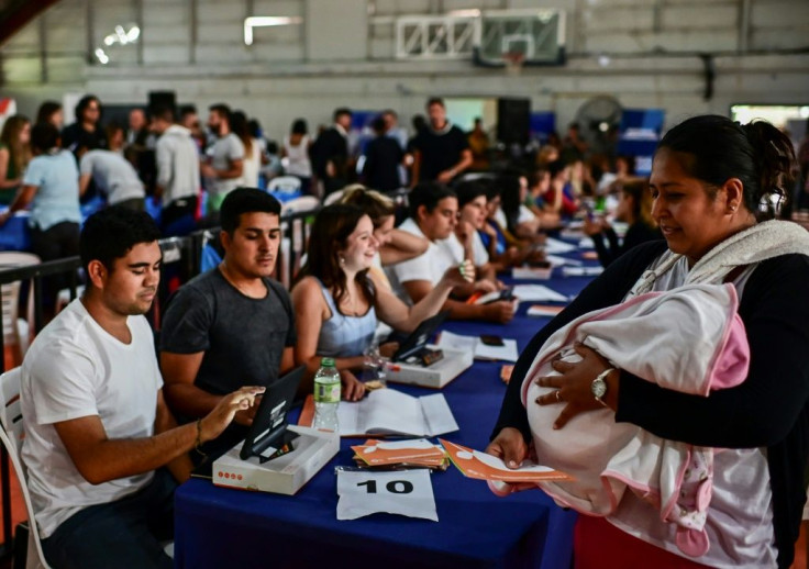 A woman with a baby collects a government-issued food card in Lomas de Zamora, close to the capital Buenos Aires