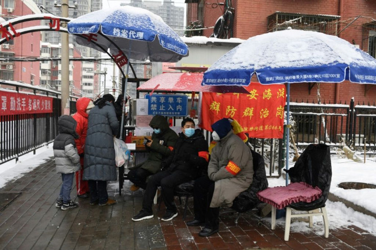 Residents monitor the entrance to a compound in Beijing. Some neighbourhoods are prompting residents to scan a QR code to fill out personal details, including their phone number and hometown address