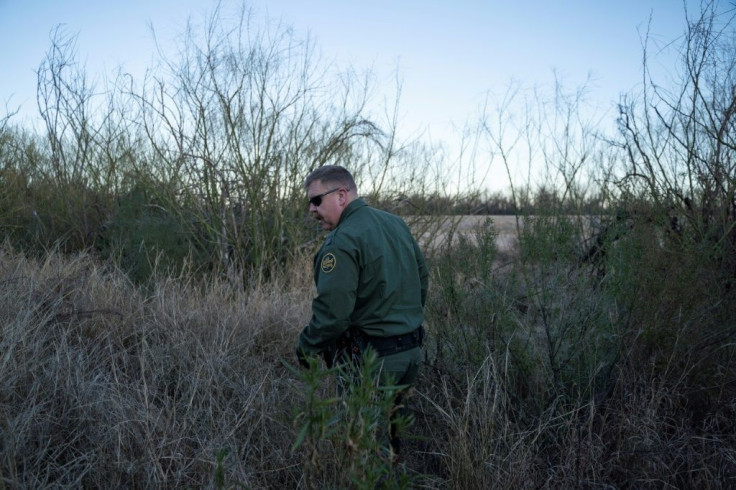 Derek Boyle, the agent in charge of the Border Patrol station in Presidio, Texas, walks through tall grass on the US-Mexico border