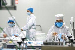 Workers produce protective masks at a factory in Qingdao, Shandong province in eastern China, during the deepening coronavirus crisis