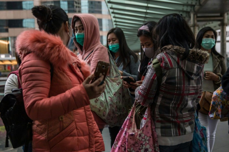 Women wearing protective face masks chat in Hong Kong, which has seen 26 cases of the new virus