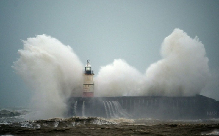 Waves crash over Newhaven Lighthouse on the south coast of England