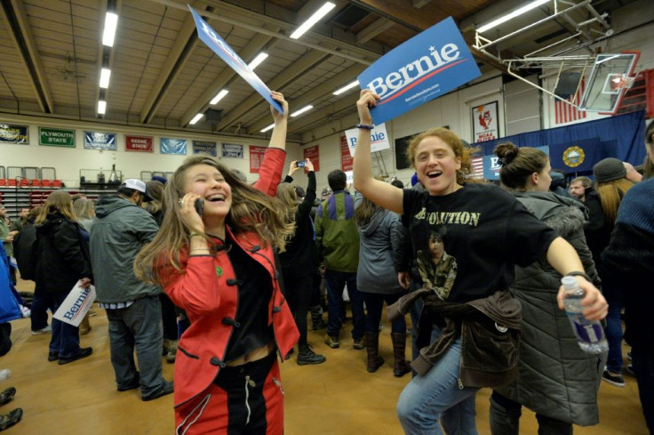 Supporters of US Presidential Candidate Senator Bernie Sanders cheer and wave campaign signs as they await his arrival at a campaign rally at Keene State College in Keene, New Hampshire on February 9, 2020.