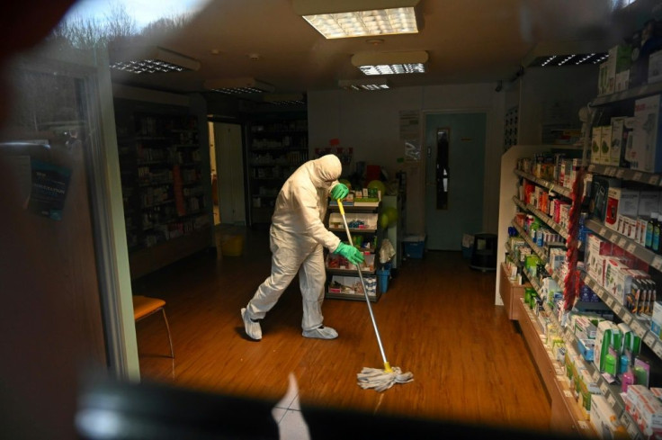 A medical worker cleans the floor of a pharmacy attached to a medical centre in Brighton, English