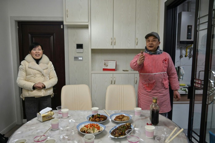 Pen Lixing (R) and his wife Wang Yangong welcome a team of foreign journalists to their apartment for the eve of the Lunar New Year in Wuhan