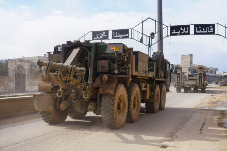 A Turkish military convoy passes through the Idlib province town of Binnish on its way to reinforce observations posts set up across northwestern Syria under a 2018 truce deal