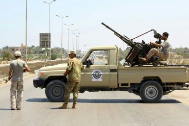 Libyan security forces stand guard at a checkpoint on August 23, 2018