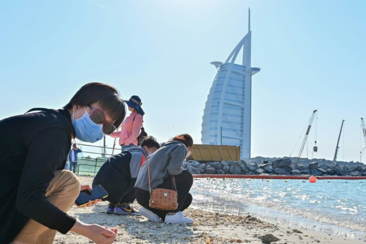 Tourists wearing surgical masks on a Dubai beach