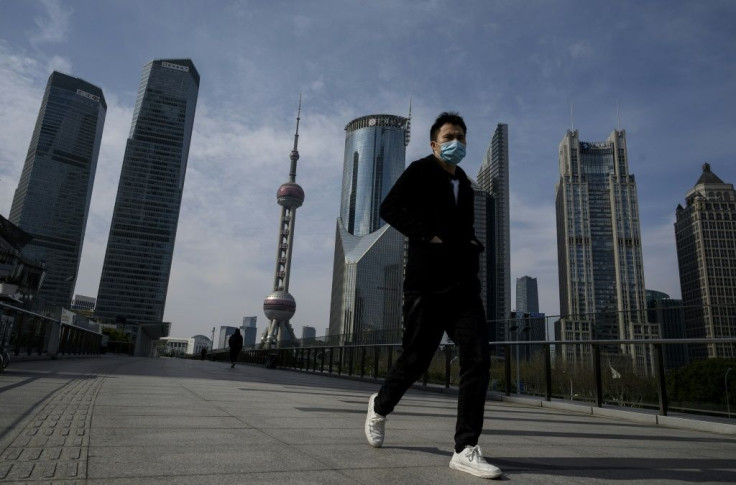 A man wearing a protective face mask walks on an overpass in Shanghai's Lujiazui financial district as officials announce the postponement of the April 19 Formula One Grand Prix