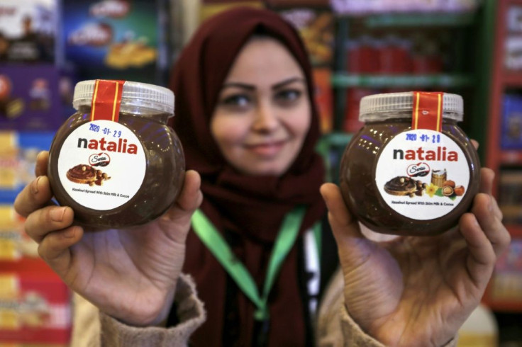 A shop employee holds up jars of a Gazan version of a world famous spread, dubbed 'Natalia'